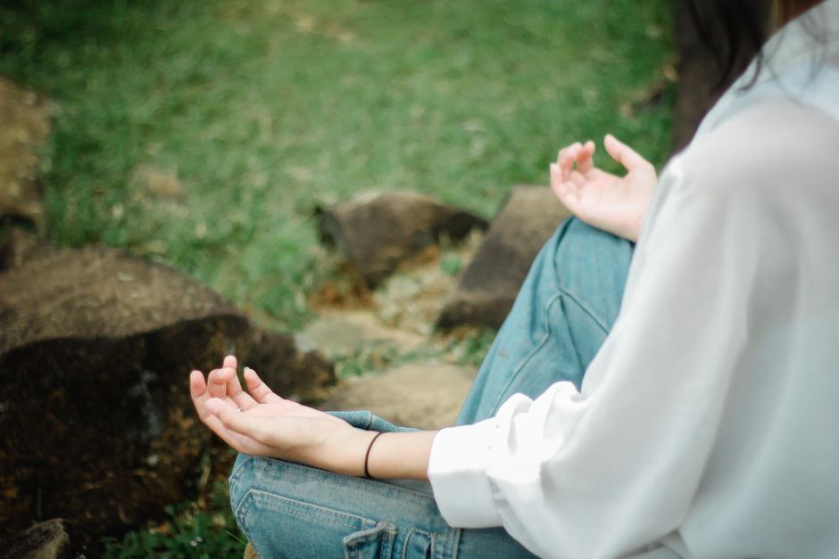 Person meditating outdoors in nature, embracing mindfulness and tranquility